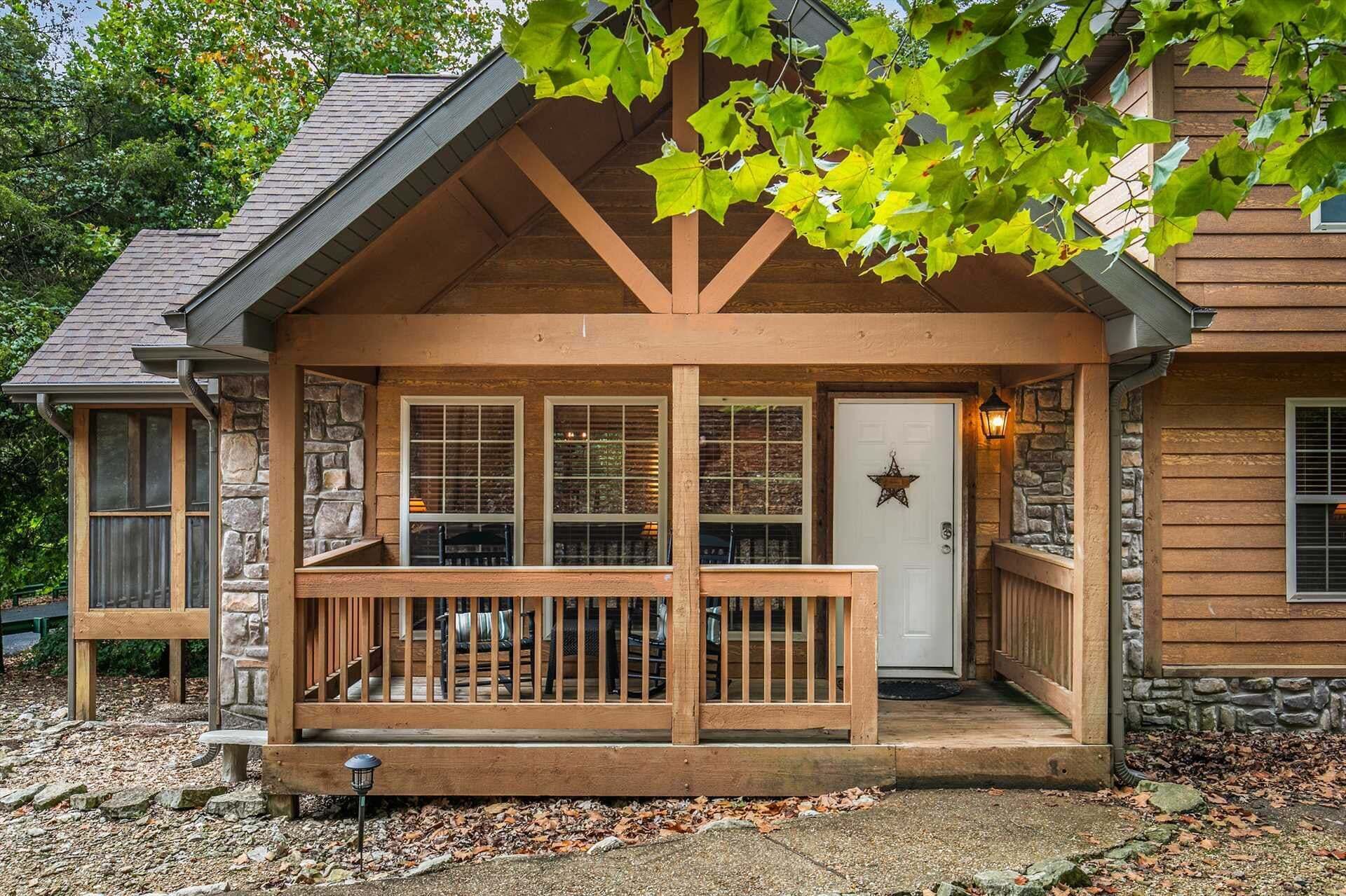Een houten hut met een stenen fundering, een veranda met een leuning, en een deur met sterdecoratie.