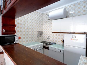 Eine Küche mit Mikrowelle, Herd, Spüle und Kühlschrank.