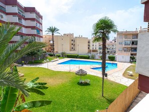 A residential building with a swimming pool, green lawn, and palm trees. - Corona 204 Apartment by Casasol by Interhome (Nerja)