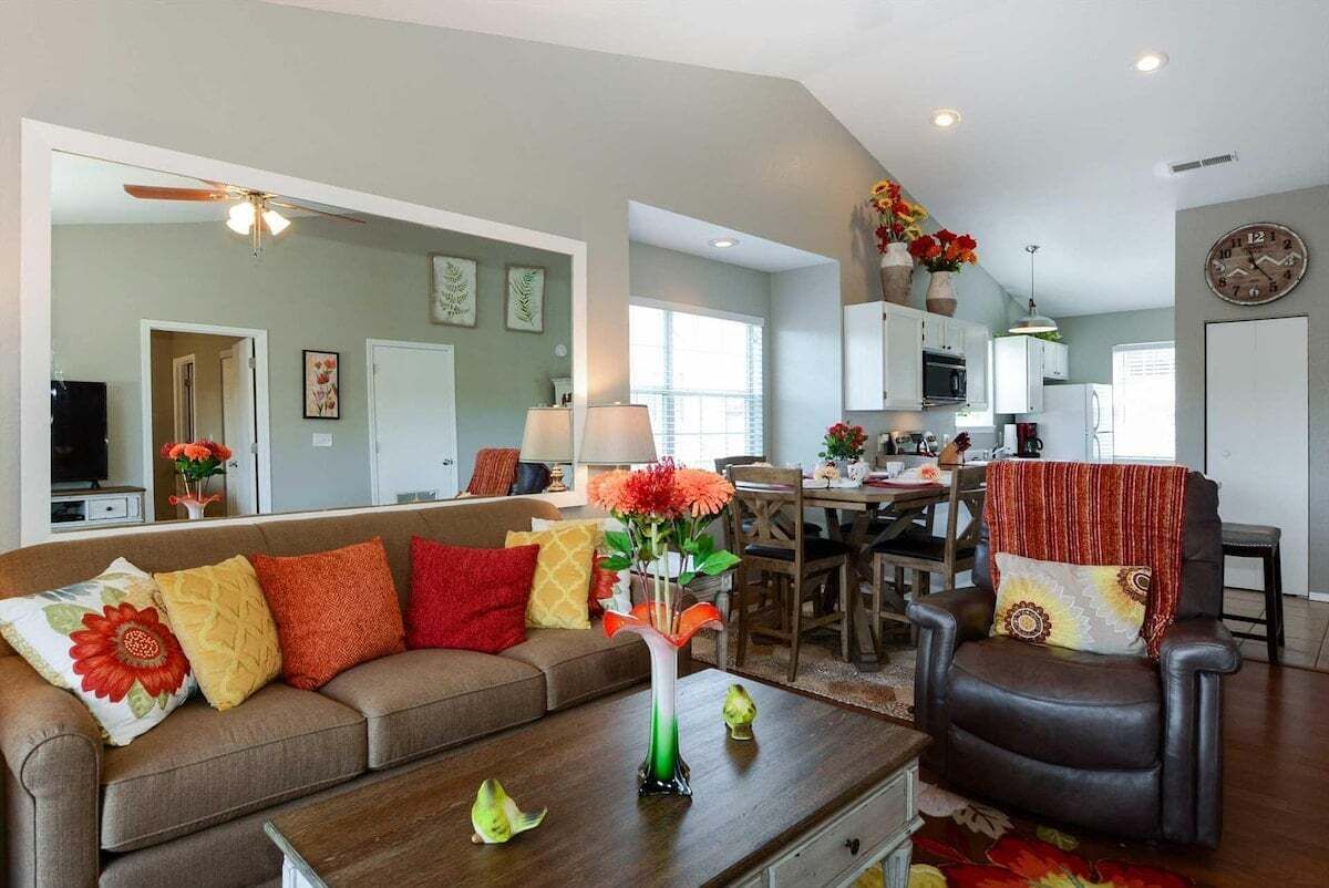 A living room with a sofa, coffee table, and a dining area with chairs and a table.