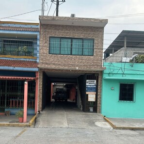 A two-story building with a visible entrance and a sign indicating a legal office. - Hotel Alex (Cunduacán)