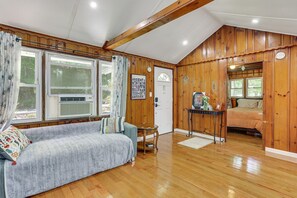 Une pièce chaleureuse avec un décor intérieur en bois, un canapé, une petite table et un lit.