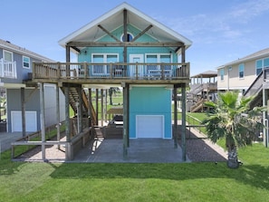 A two-story house with a balcony, a garage, and a well-maintained lawn. - A Sandy Hope Direct Beach Access Sleeps 12 (Bolivar Peninsula)
