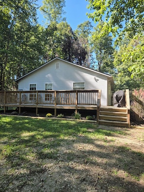 A single-story house with a wooden deck and a covered porch.