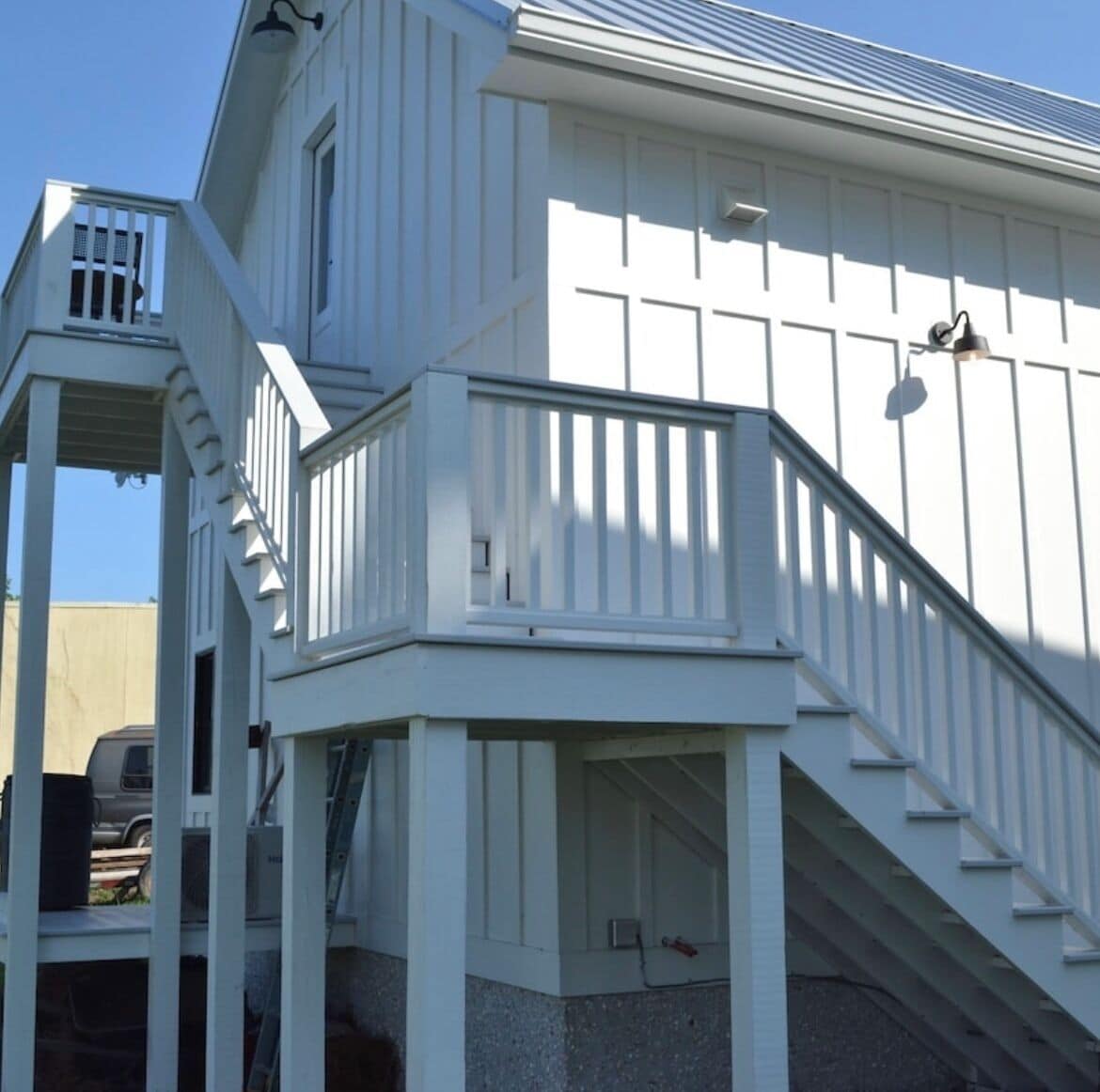 A white building with a staircase leading to a balcony.