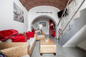 A living room with a sofa, a coffee table, and a staircase. - Casa Teresa — city house with sea view (Olhão)