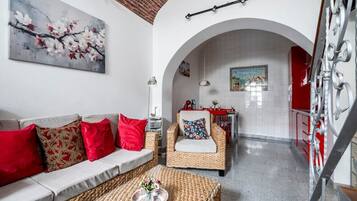 Una sala de estar con sofá, sillón y comedor con mesa y sillas.