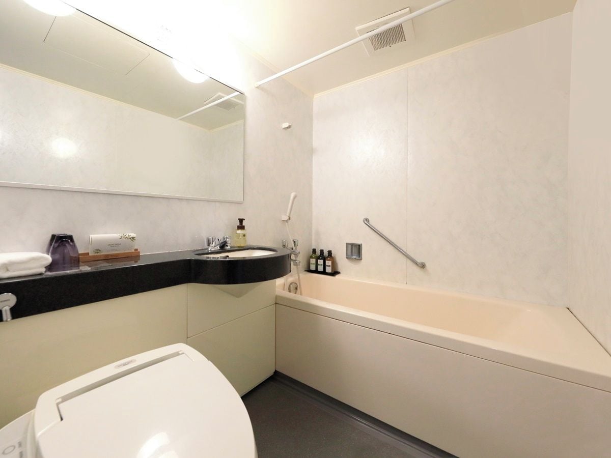 A modern bathroom with a toilet, sink, and bathtub.