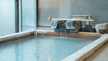 A hot spring with a wooden bench and a stone ledge.