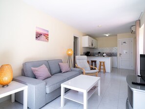 Ein modernes Wohnzimmer mit einem grauen Sofa, einem weißen Couchtisch und einer Stehlampe.