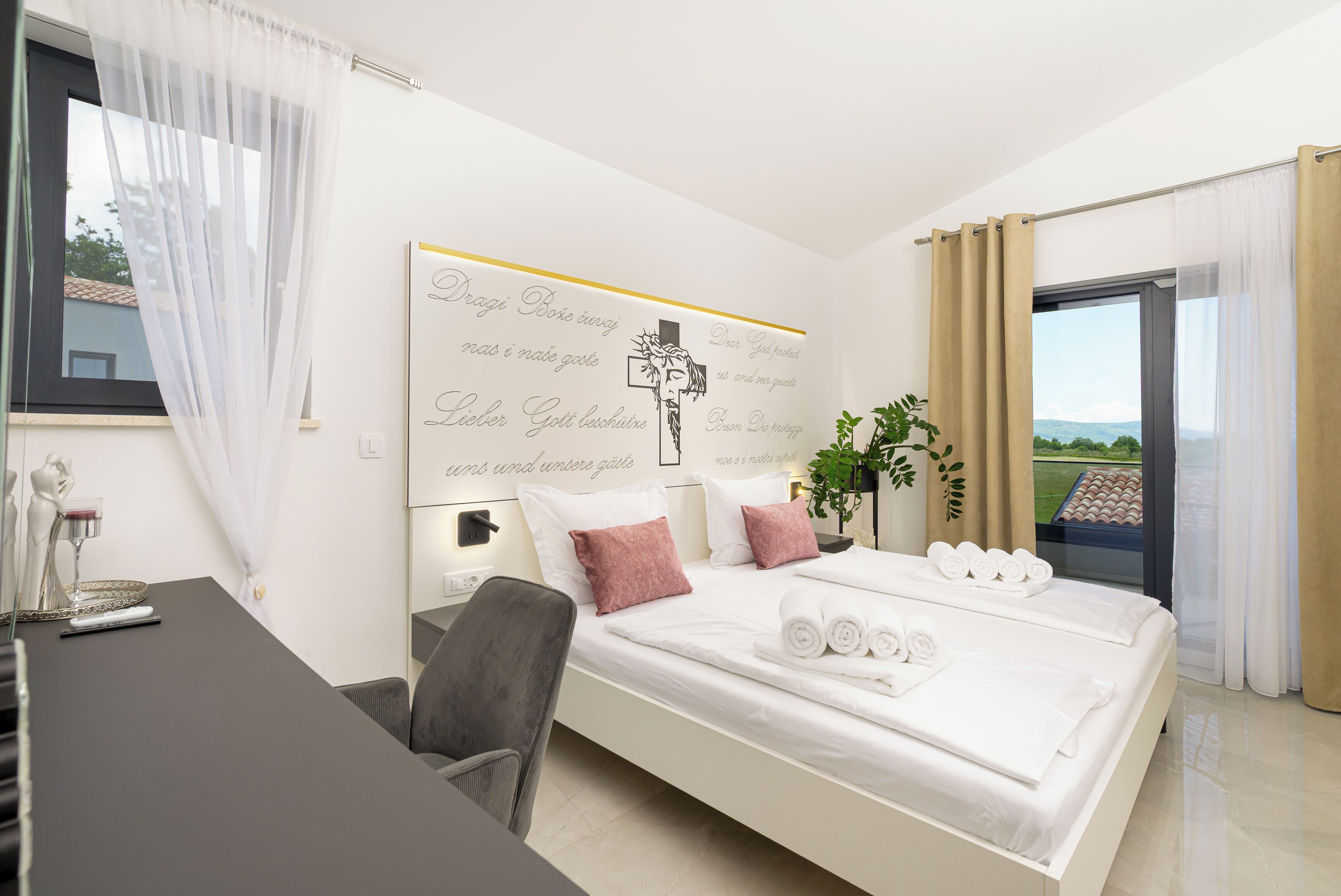 Een hotelkamer met een bed, een bureau, een stoel, een plant en uitzicht op de omgeving.