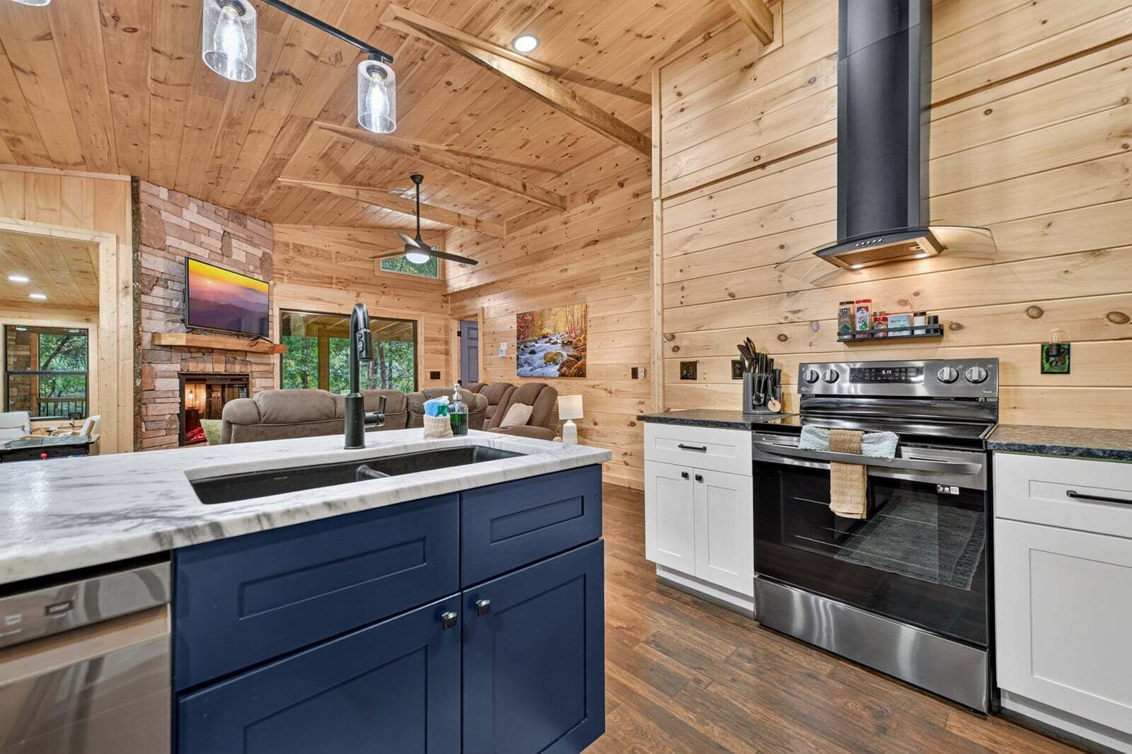Una cucina moderna con isola centrale, elettrodomestici integrati e un camino in pietra.