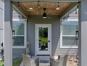 A covered porch with a ceiling fan, two windows with blinds, and wicker furniture. - Cozy 2/2.5 Close to Lake Conroe, Pool, Golf Course, Tennis & Country Club! (Montgomery)