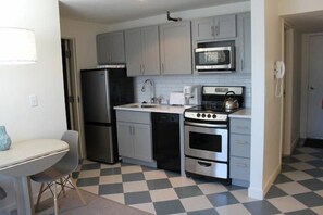 A compact kitchen with a refrigerator, microwave, stove, and sink. - Sugarloaf Mountain Gondola Village C2202 (Carrabassett Vly)