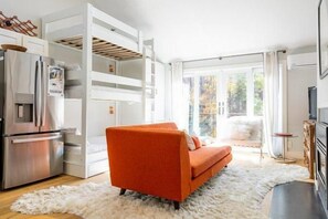 A modern kitchen with a built-in refrigerator and a dining area with a white rug. - Sugarloaf Mountain Sugartree I  C374 (Carrabassett Vly)