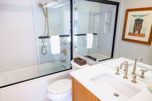 A bathroom with a glass shower enclosure, a white toilet, a sink with a mirror, and a framed picture on the wall. - Sugarloaf Mountain Sugartree I  C374 (Carrabassett Vly)