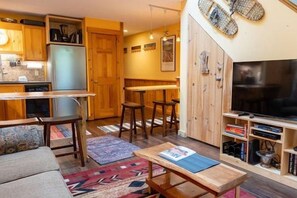 Ein kompakter Wohnbereich mit Küchenzeile, Essbereich, einer Sitzecke mit Sofa und Fernseher.