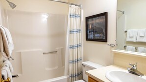 A bathroom with a bathtub, toilet, and sink. - Sugarloaf Mountain Snowbrook Village C2573 (Carrabassett Vly)