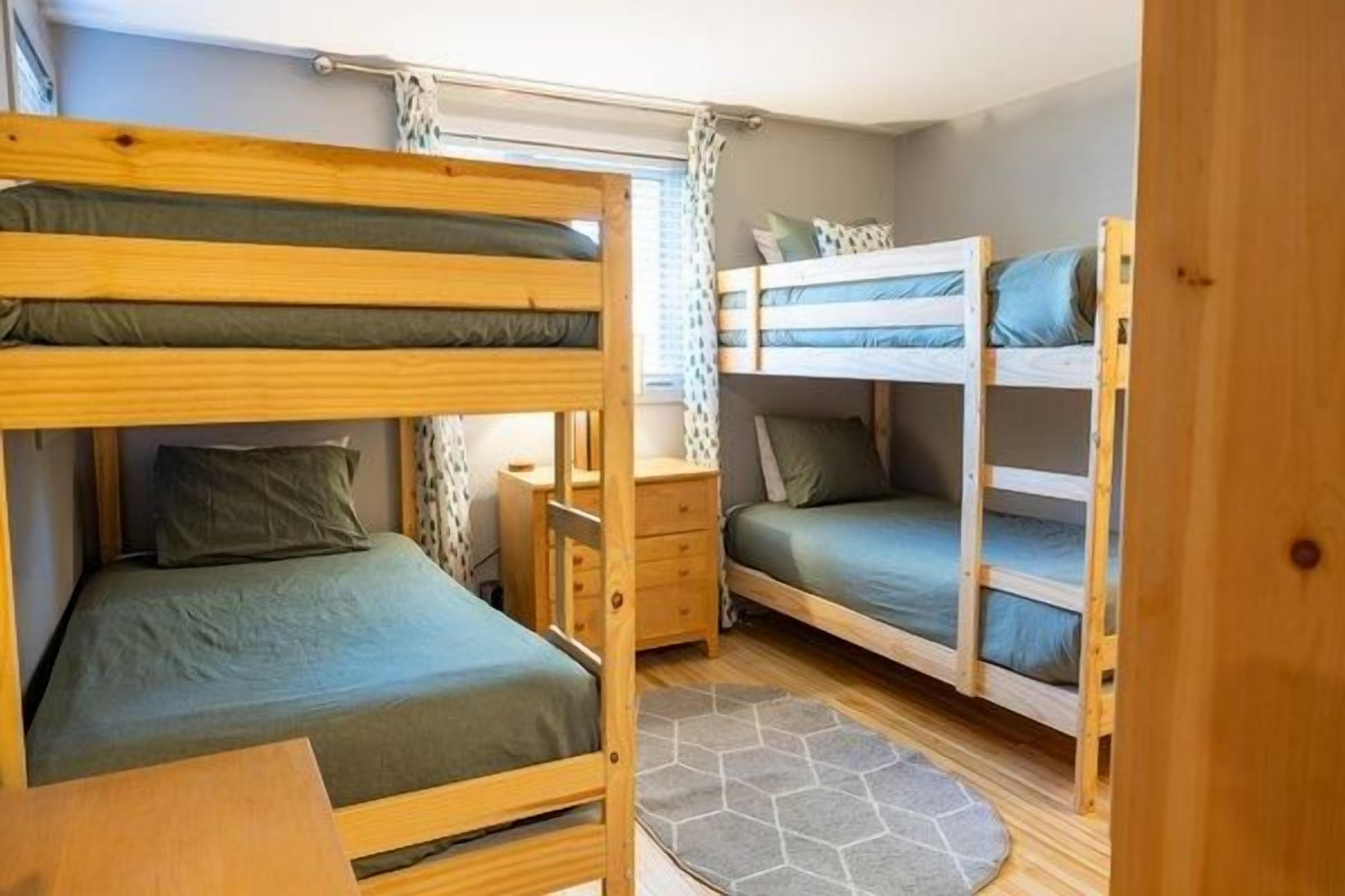Une chambre avec un lit superposé, un bureau et une fenêtre.