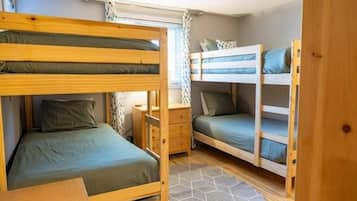 Une chambre avec un lit superposé, un bureau et une fenêtre.