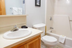 Ein Badezimmer mit Waschbecken, Toilette und Badewanne.