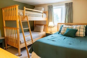 A bunk bed with a ladder, a bedside table with a lamp, and a window with curtains. - Sugarloaf Mountain Snowbrook Village C2648 (Carrabassett Vly)