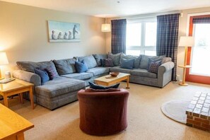 A living room with a sofa set, a round ottoman, a coffee table, and a lamp. - Sugarloaf Mountain Snowbrook Village C2648 (Carrabassett Vly)