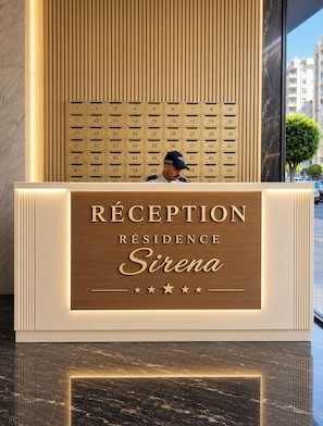 A reception desk with a directory of room numbers and the name 'Sirena' indicating the hotel or residence. - Modern 2BR Apartment with Central AC Near Beach & TGV (Tanger)