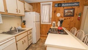 A kitchen with wooden cabinets, a refrigerator, a stove, and a coffee maker. - Sugarloaf Mountain Birchwood II C827 (Carrabassett Vly)