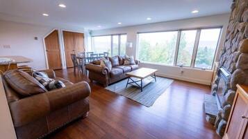 A spacious living area with a stone accent wall, a large window, and a dining area.