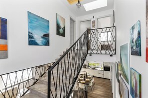 A modern interior with a staircase, dining area, kitchen, and artwork on the walls. - Vila Helios in Pomer by Istrabook (Pomer)