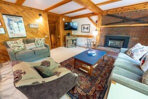 A cozy living room with a sofa, a coffee table, and a fireplace. - Sugarloaf Mountain Birchwood III  C728 (Carrabassett Vly)