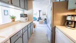 Una cocina equipada con microondas, cafetera y refrigerador.