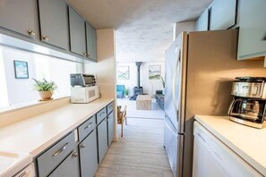 Eine Küche mit Mikrowelle, Kaffeemaschine und Kühlschrank.