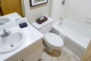 Een badkamer met een wastafel, toilet en bad.