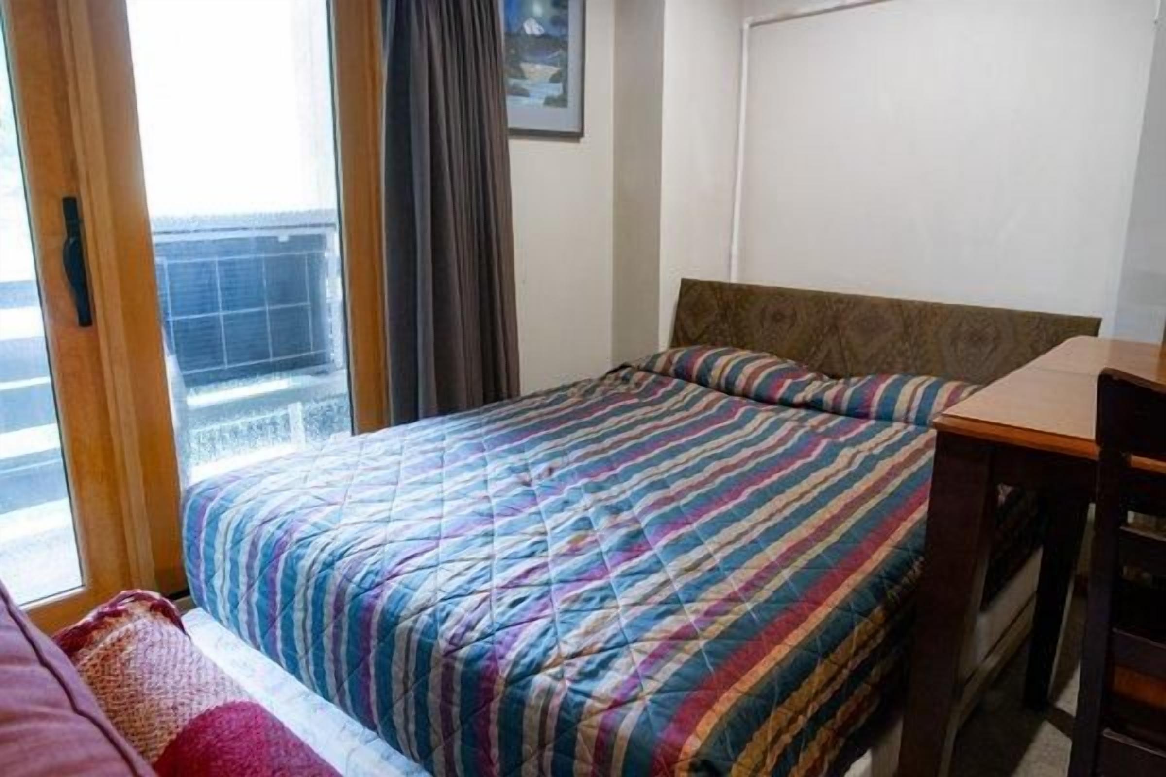 Et hotelværelse med en seng, et vindue og udsigt ud