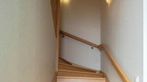 Eine Holztreppe mit Handlauf und einer Lampe am oberen Ende.