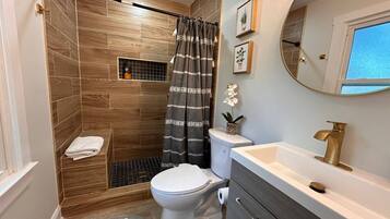 Un bagno con doccia, WC, lavandino e mobile lavabo.