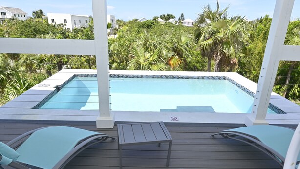A pool area with a hot tub, two lounge chairs, and a small table. - Brand New Beach Cottage with Pool, Walk to La Bougainvillea Restaurant and Bar (Governor's Harbour)