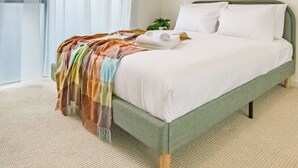 Ein Hotelzimmer mit einem Bett, einem Fenster mit Vorhängen, einer Klimaanlage und einem Bild an der Wand.