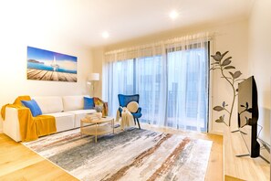 Ein modernes Wohnzimmer mit einem weißen Sofa, einem blauen Sessel und einem Couchtisch.