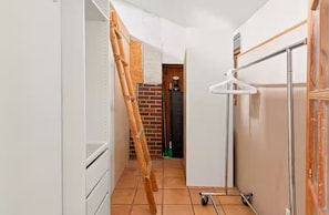 A narrow hallway with a bamboo ladder, a white refrigerator, and a green mop. - Garden Loft close to CU, trails and Pearl Street (Boulder)