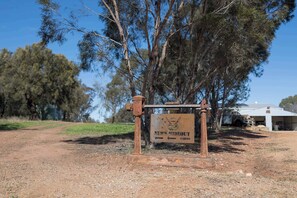 A rustic metal sign with 'Ned's Hideout' and 'Cabins' indicating a rural accommodation.