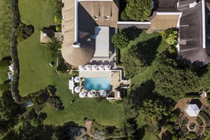 An aerial view of a property with a swimming pool, lounge area, and landscaped garden. - Elegant Merlot Room with Captivating Panoramas 1038 (Western Cape)