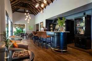 A bar area with a wooden ceiling, hanging lights, and a bar counter with a plant. - Elegant Merlot Room with Captivating Panoramas 1038 (Western Cape)