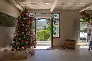 A room with a Christmas tree, a wooden barrel, and a view of a mountain landscape through a window. - Elegant Merlot Room with Captivating Panoramas 1038 (Western Cape)