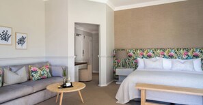 Ein Hotelzimmer mit einem Bett, einem Schlafsofa, einem runden Tisch und einem Nachttisch.