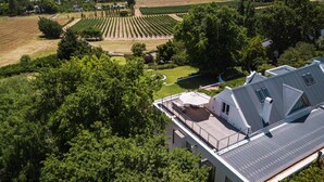 Ein Wohngebiet mit einem großen Weinberg, einem Schwimmbad und einem modernen Haus mit Satteldach.
