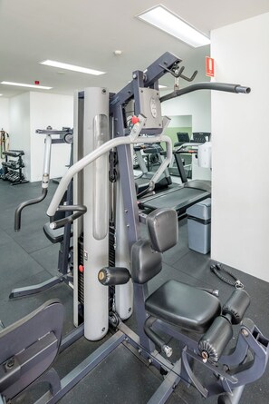 Une salle de sport équipée de matériel d’exercice, de tapis de course et d’appareils de musculation.