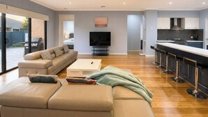A modern living room with a sofa, a coffee table, and a TV.